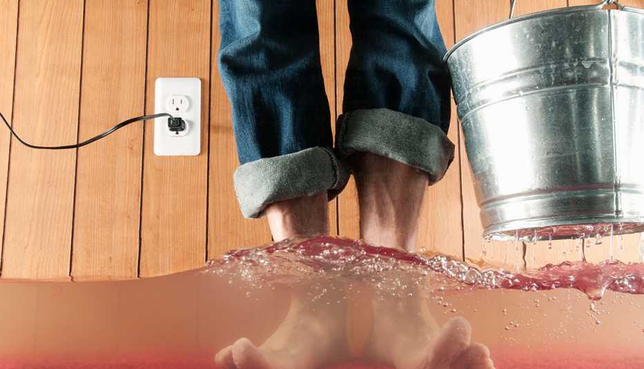 Primer plano de una persona cargando un cubo y con pies sumergidos en agua hasta los tobillos.