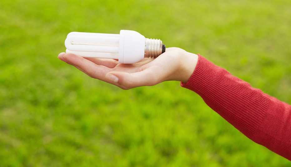 Mano de una mujer sosteniendo un bombillo
