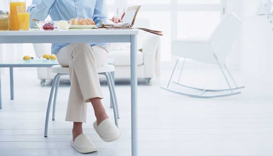 Cómo prevenir caídas en la cocina - Mujer desayuna en la cocina Cómo prevenir caídas en la cocina - Mujer desayuna en la cocina
