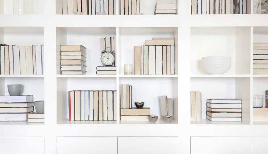 Estantería blanca con libros y objetos decorativos