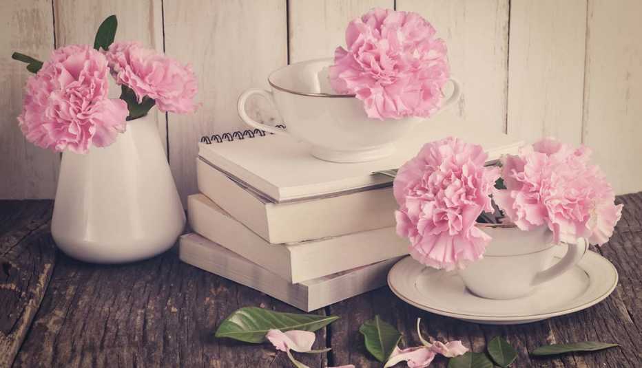 Dos tazas una jarra blancas con claveles rosa