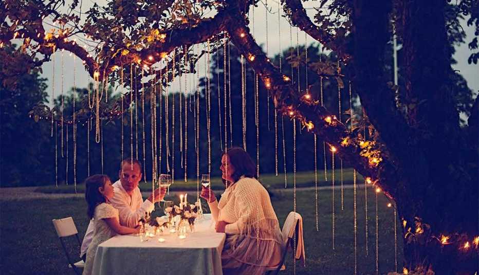 Familia celebrando en un jardín con flores colgando de un árbol