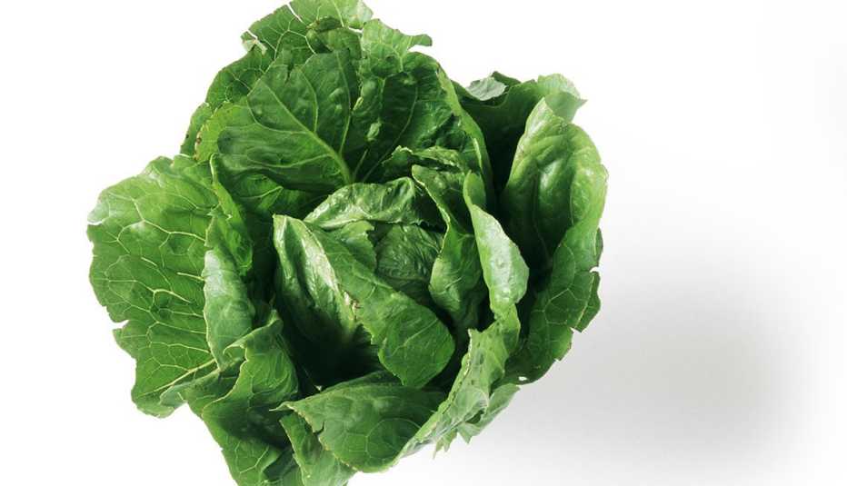Una lechuga romana sobre una superficie blanca