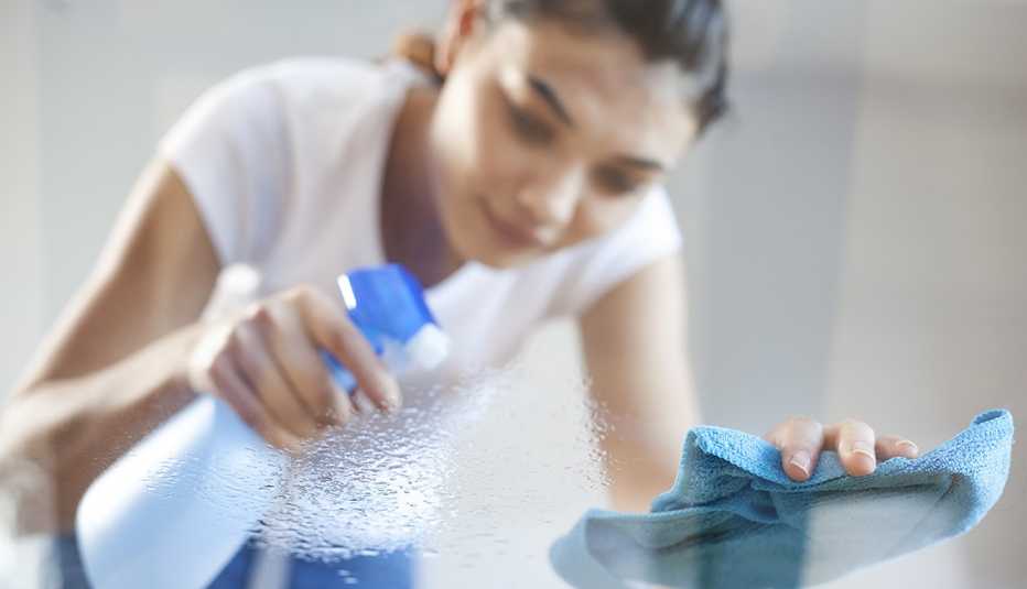 Mujer limpiando con atomizador