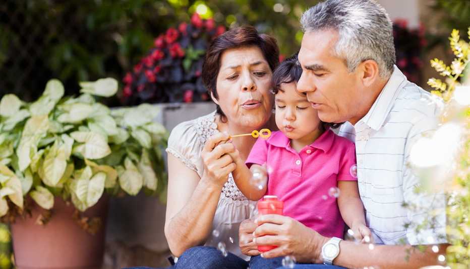 Dos abuelos soplan burbujas con un niño pequeño Dos abuelos soplan burbujas con un niño pequeño