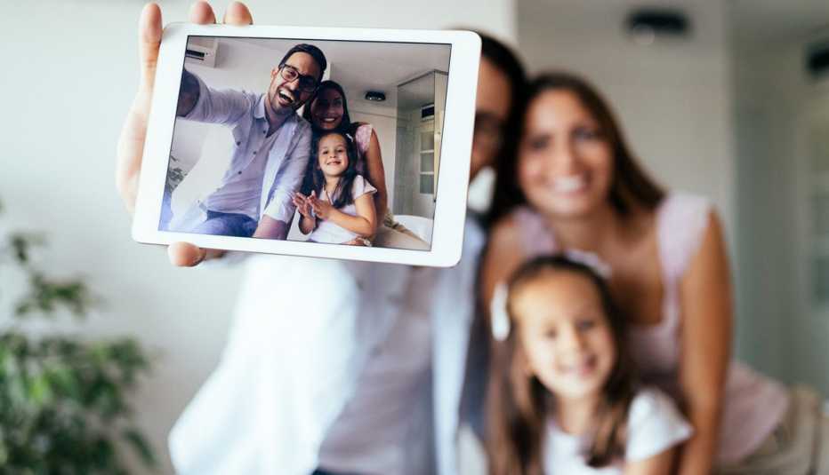 Una pareja y su hija se toman una foto con el teléfono inteligente.