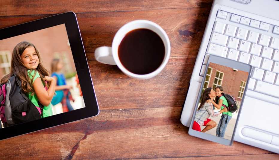 Tableta electrónica y teléfono muestran fotos. Al lado tienen una taza de café y una computadora portátil.