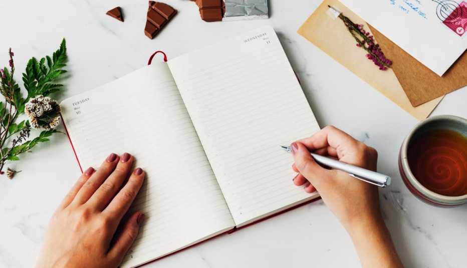 Una persona se prepara para escribir en un cuaderno.