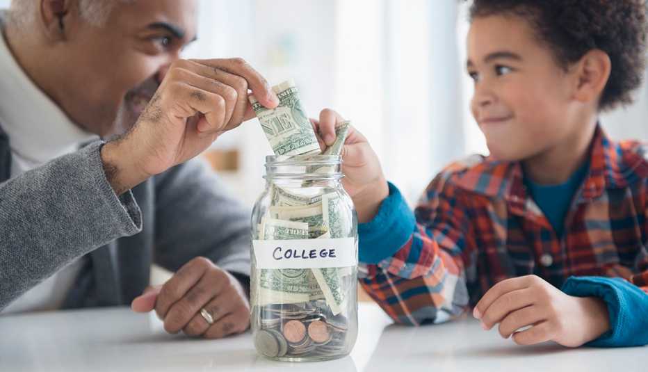 Un hombre mayor y un niño poniendo dinero en un frasco Un hombre mayor y un niño poniendo dinero en un frasco