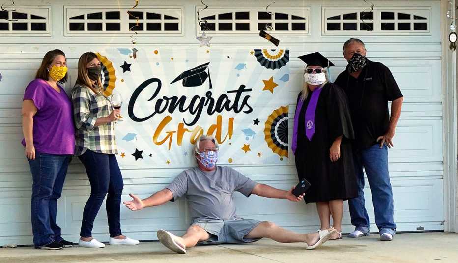 Familia con mascarillas posan para una foto frente a la puerta de su garaje Familia con mascarillas posan para una foto frente a la puerta de su garaje
