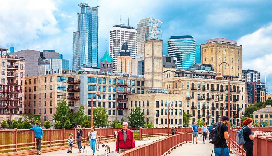 Gente caminando sobre el puente de arco de piedra sobre el río Mississippi en Minneapolis