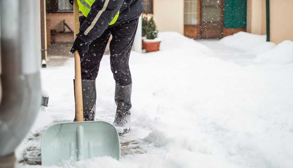 Persona quitando la nieve con una pala