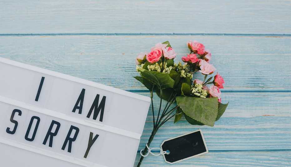 Ramo de flores junto a una nota que dice I am sorry