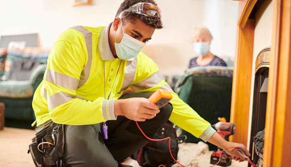 Un electricista trabaja en la sala de estar de una casa