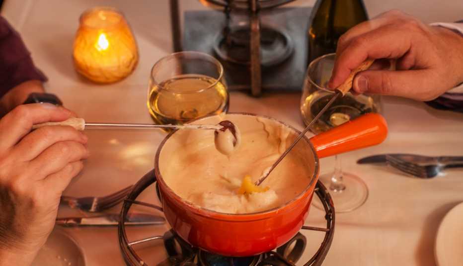 Dos personas disfrutan de un fondue en un restaurante Dos personas disfrutan de un fondue en un restaurante