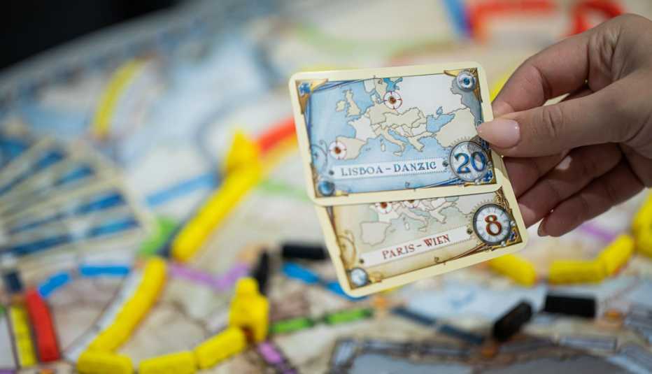 Persona sostiene dos cartas en un juego de mesa