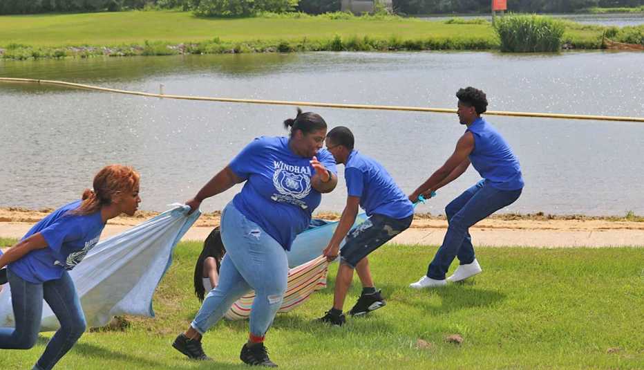 Familia juega al aire libre junto a un lago