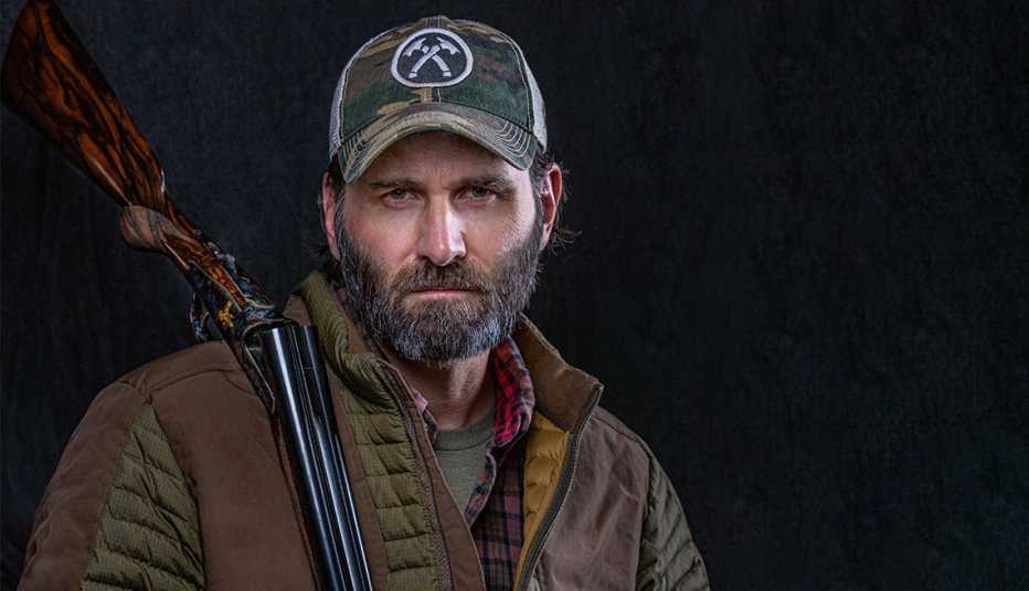 El exitoso autor Jack Carr es conocido por novelas de suspenso como ‘The Terminal List’ jack carr mira a la cámara en este retrato de cerca con un rifle sobre su hombro