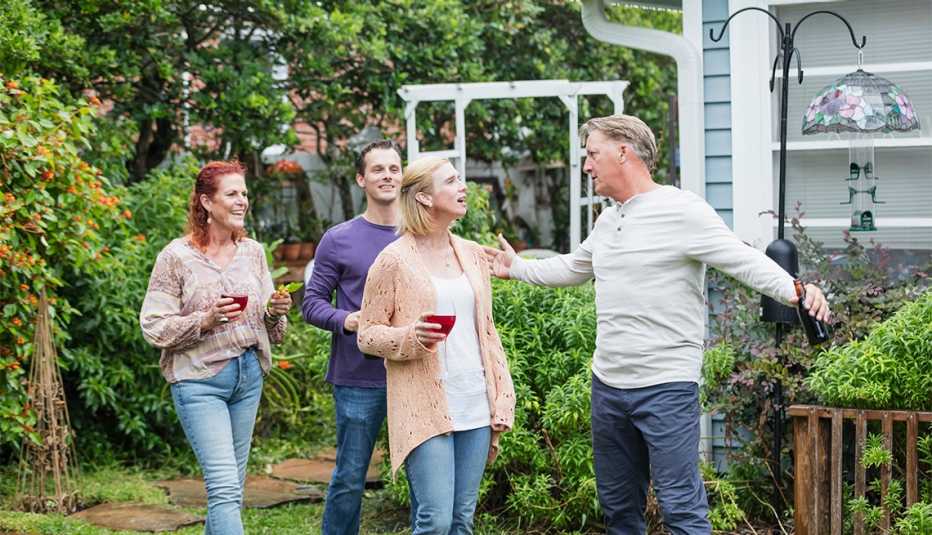 Dos hijos adultos con sus padres en el patio de la casa