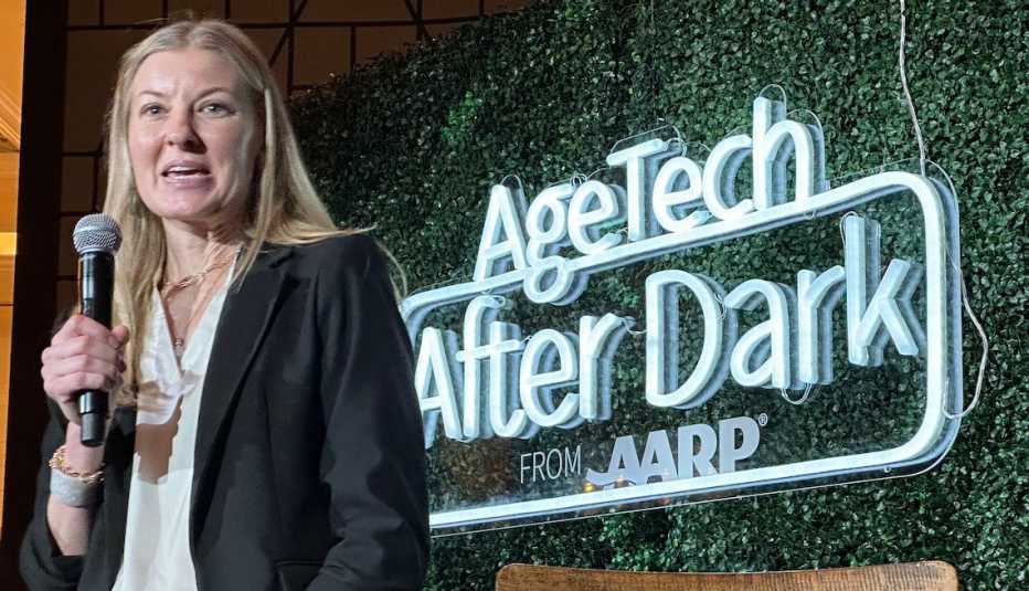 Kim Petty habla por un micrófono con las palabras agetech after dark en el fondo