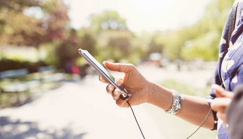 Mujer sostiene en la mano un teléfono inteligente