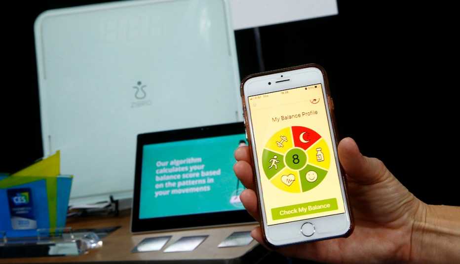 Persona sostiene un teléfono en la mano mientras muestra la aplicación Balance Coach Persona sostiene un teléfono en la mano mientras muestra la aplicación Balance Coach