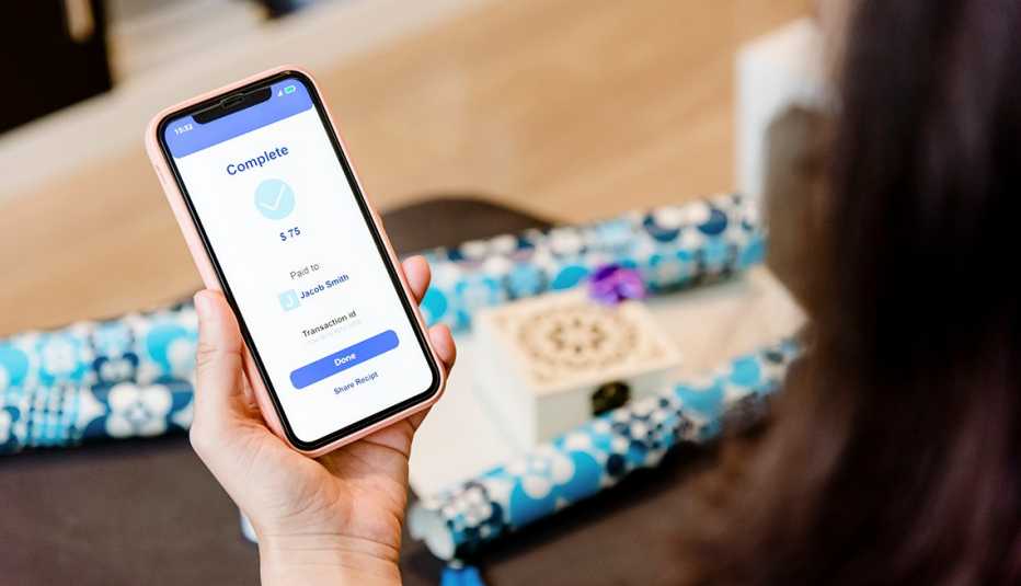Mujer enviando dinero a través de un teléfono celular Mujer enviando dinero a través de un teléfono celular
