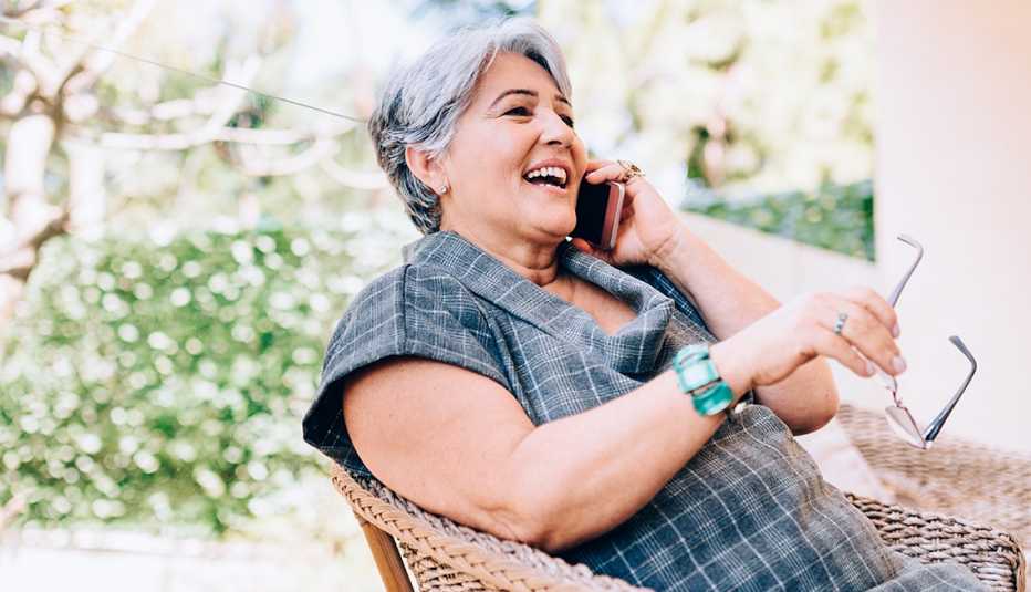 Una mujer sonríe mientras habla por teléfono