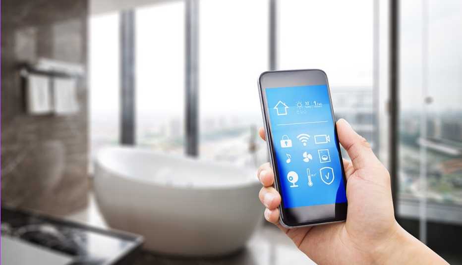 Persona sostiene un dispositivo móvil en el baño