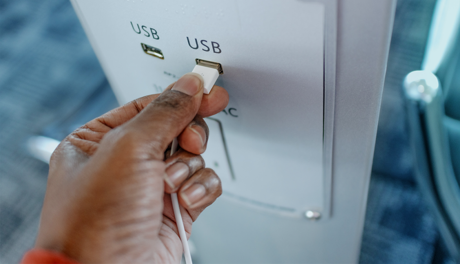 Hombre conecta un cargador a un puerto USB en un lugar público