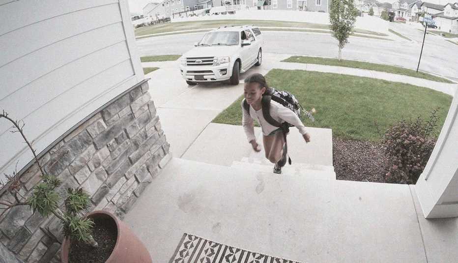 Niña vista entrando a su casa desde la cámara del timbre inteligente