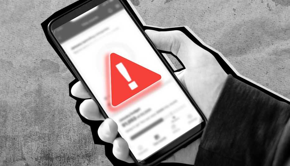 Una mano sostiene un teléfono celular con un símbolo de advertencia