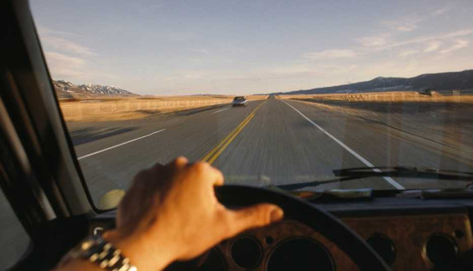 Mano de un hombre en el volante de un vehículo Mano de un hombre en el volante de un vehículo