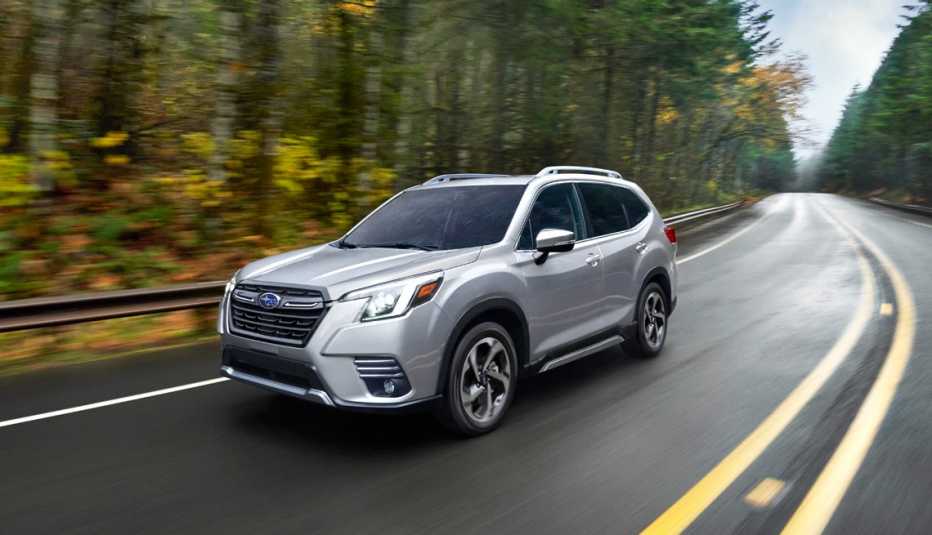 Subaru Forester conduciendo a través de un bosque en otoño