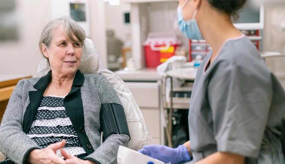 Senior female patient having blood pressure taken during medical examination appointment 