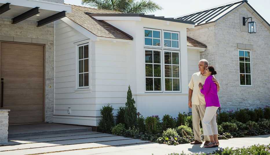 Pareja en el exterior de una casa nueva
