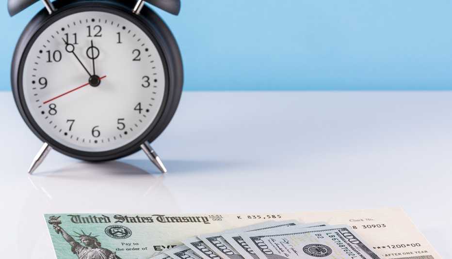 Reloj despertador de cuerda con billetes de 100 dólares y bonos del tesoro.