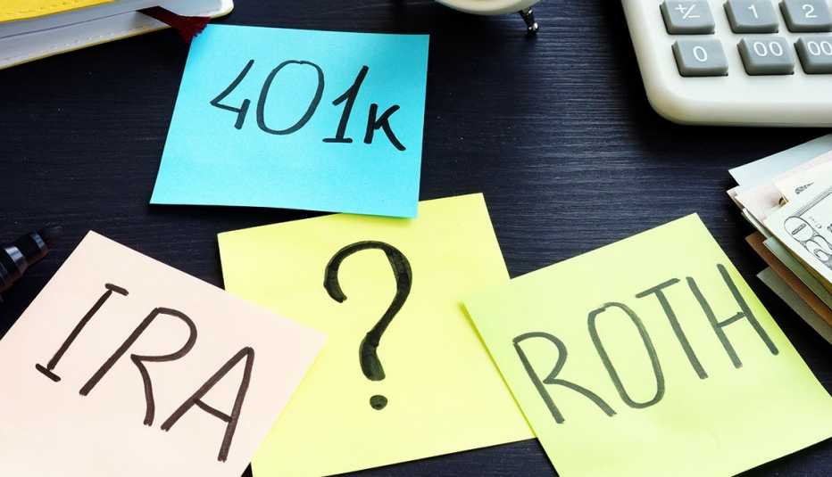 Notas sobre 401k, IRA y Roth en un escritorio con un signo de interrogación en el medio
