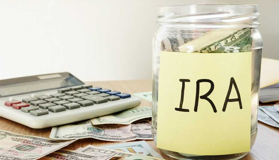 IRA escrito en una etiqueta pegada a un frasco con dólares.