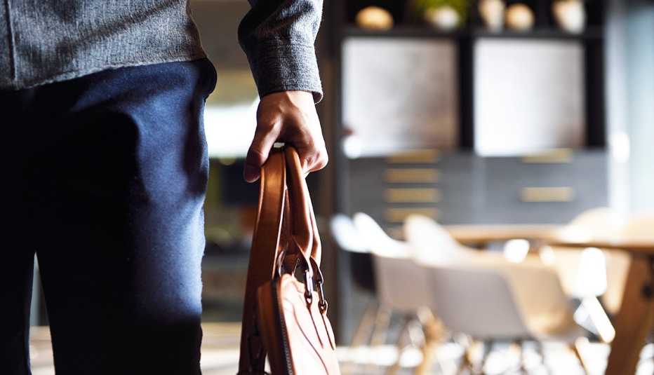 Hombre sostiene un maletín de trabajo.