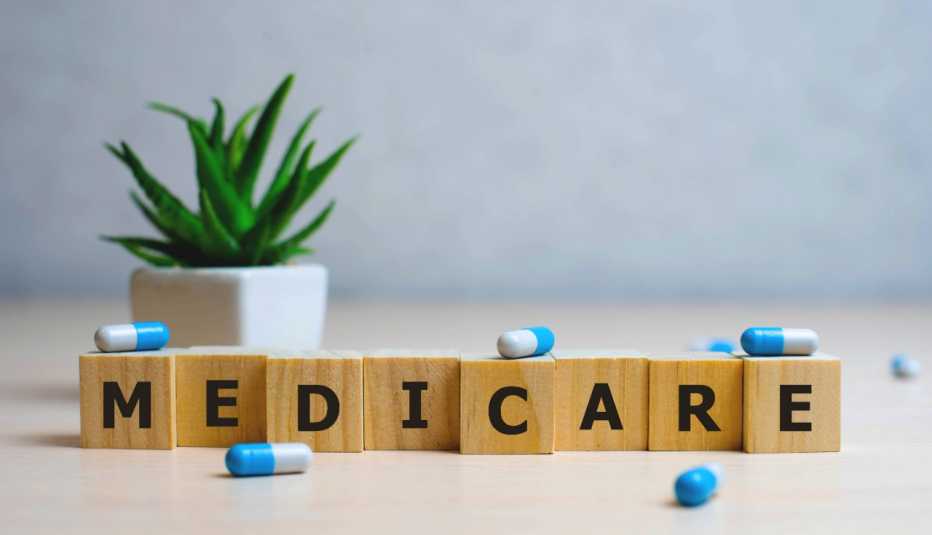 Bloques que forman la palabra Medicare, varias pastillas y al fondo una planta