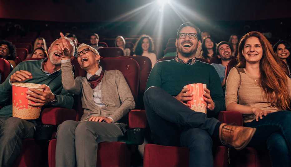 several people sitting in a movie theater enjoying a comedy