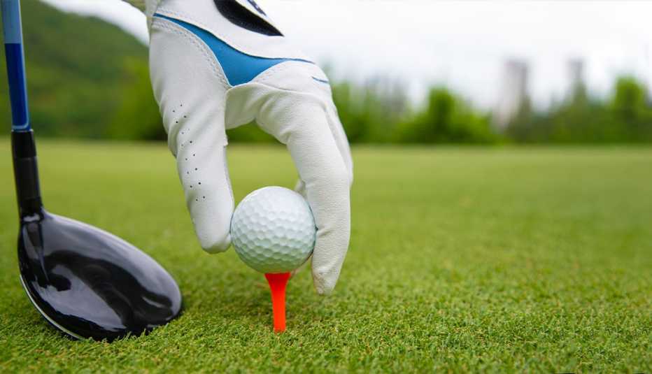 Golfista colocando una pelota en un tee.