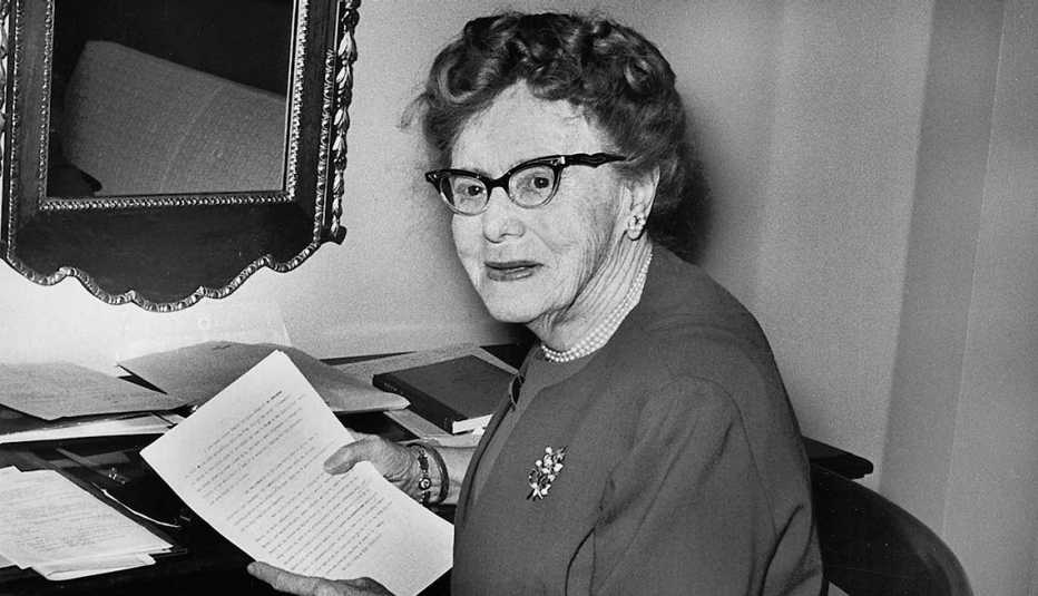 Ethel Percy Andrus sentada mientras sostienen un documento en las manos.