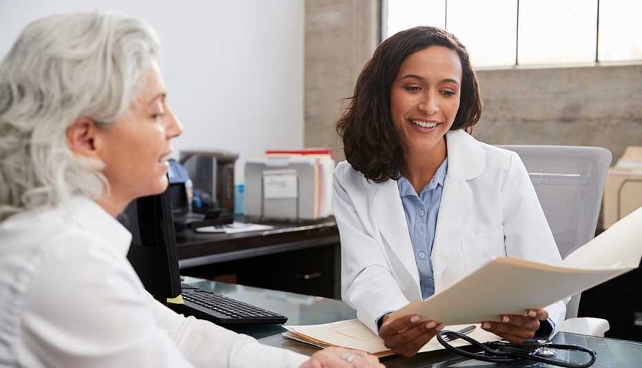 Una doctora sostiene el expediente de una paciente en consulta