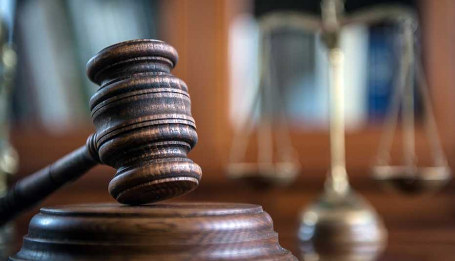 Un mazo de madera marrón con una balanza en el fondo