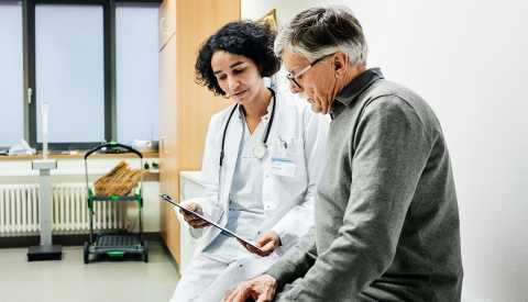 Doctora habla con un hombre mayor