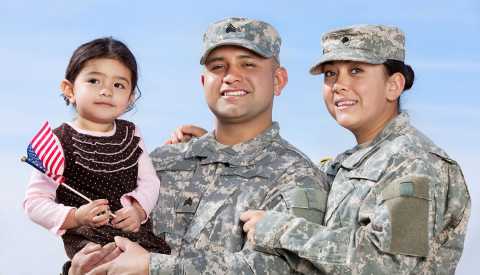 Pareja vestida con uniforme militar posa junto a su hija para una foto Pareja vestida con uniforme militar posa junto a su hija para una foto