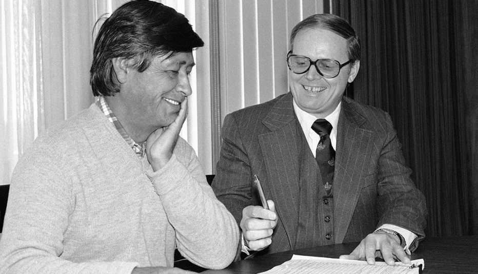 El Secretario de Trabajo Ray Marshall (der.), firma un contrato de $500.000 con César Chávez