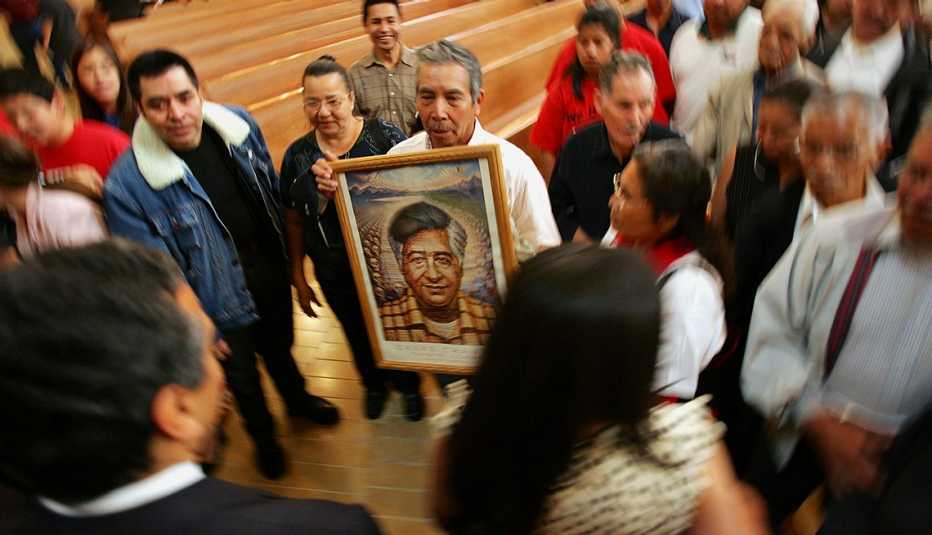 Un hombre sostiene un retrato de César Chávez
